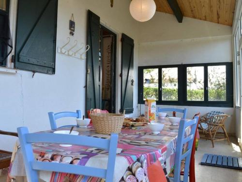 une salle à manger avec une table et des chaises bleues dans l'établissement Maison avec Jardin, 5 couchages, St Pierre la Mer - Lave-vaisselle, Lave-linge, Animaux acceptés - FR-1-229D-211, à Saint Pierre La Mer