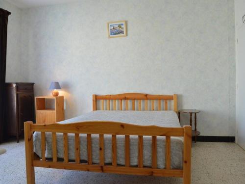 une chambre avec un lit en bois dans une pièce dans l'établissement Villa 5 pièces avec annexe, proche plage et commerces, terrasse et parking, SAINT PIERRE LA MER - FR-1-229D-209, à Saint Pierre La Mer