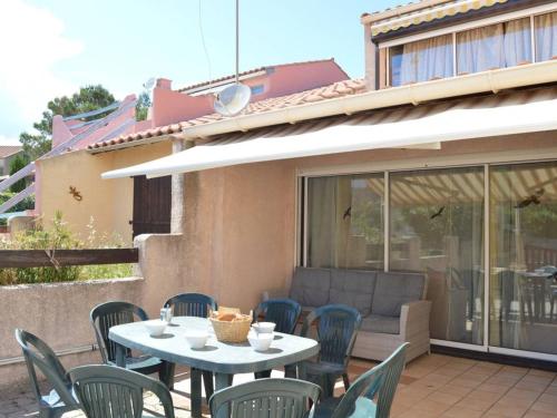 une table et des chaises assises sur une terrasse dans l'établissement Maison 5 pièces, 8 couchages, terrasse, proche plage et commerces - Saint Pierre La Mer - FR-1-229D-240, à Saint Pierre La Mer