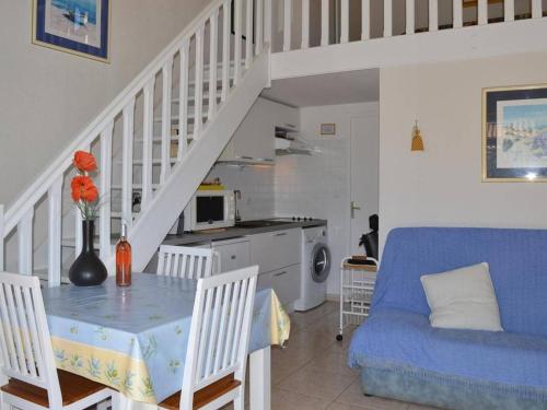un salon avec une table et un canapé bleu dans l'établissement Pavillon climatisé 6 couchages, terrasse, garage, à 750m de la plage - St Pierre la Mer - FR-1-229D-379, à Saint Pierre La Mer