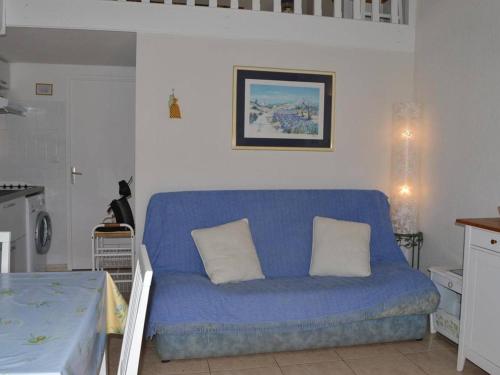 - un canapé bleu avec deux oreillers dans le salon dans l'établissement Pavillon climatisé 6 couchages, terrasse, garage, à 750m de la plage - St Pierre la Mer - FR-1-229D-379, à Saint Pierre La Mer