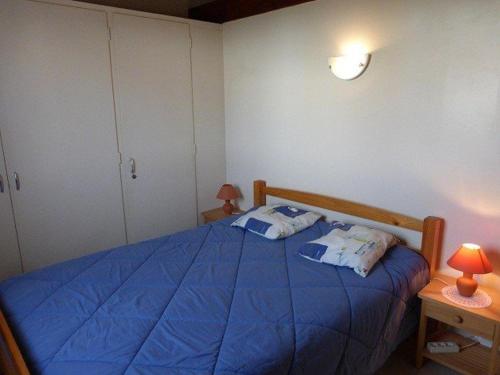 - une chambre avec un lit bleu et 2 oreillers dans l'établissement Charmante maison proche mer avec piscine chauffée, tennis et jardin - Bretignolles-sur-Mer - FR-1-224A-18, à Bretignolles-sur-Mer