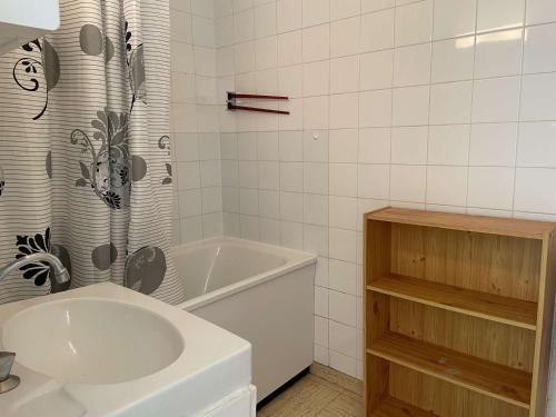 uma casa de banho com um lavatório, uma banheira e uma cortina de chuveiro em Appartement Saint-Gilles-Croix-de-Vie, 2 pièces, 4 personnes - FR-1-224-300 em Saint-Gilles-Croix-de-Vie