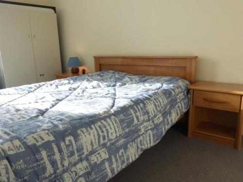 une chambre avec un lit avec une couette bleue et blanche dans l'établissement Appartement 2 pièces avec balcon et parking à Saint-Gilles-Croix-de-Vie - FR-1-224-39, à Saint-Gilles-Croix-de-Vie