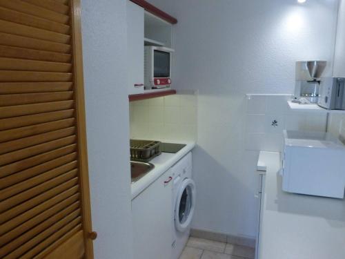- une cuisine blanche avec un lave-linge et un évier dans l'établissement Appartement 2 pièces, terrasse, proche plage, 4 couchages, St Hilaire de Riez - FR-1-224-308, à Saint-Hilaire-de-Riez
