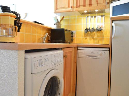 une cuisine avec une machine à laver sous un comptoir dans l'établissement Studio avec canapé convertible, au cœur du Cap d'Agde, proche plage et commerces - FR-1-249-1, au Cap d'Agde