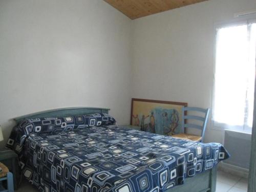 une chambre avec un lit, une chaise et une fenêtre dans l'établissement Maison à 300m de la plage avec jardin clos, terrasse, BBQ et 2 chambres - FR-1-224B-515, à LʼÉpine