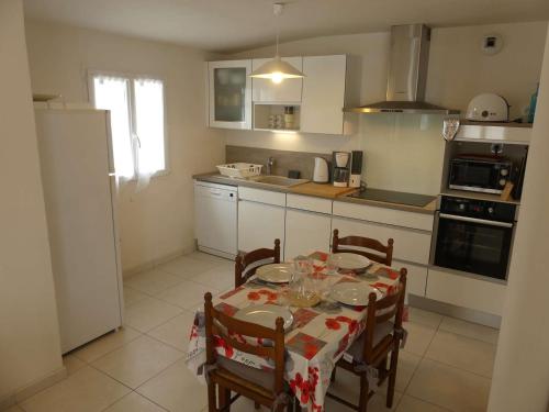 une cuisine avec une table et des chaises ainsi qu'une cuisine avec une table et des chaises dans l'établissement Maison avec terrasse, 400 m plage et centre, 2 chambres, parking privé, ménage inclus - FR-1-224B-542, à La Guérinière