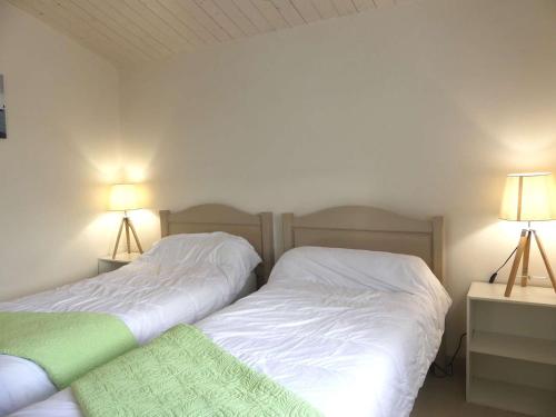 deux lits côte à côte dans une chambre dans l'établissement Maison avec terrasse, 400 m plage et centre, 2 chambres, parking privé, ménage inclus - FR-1-224B-542, à La Guérinière