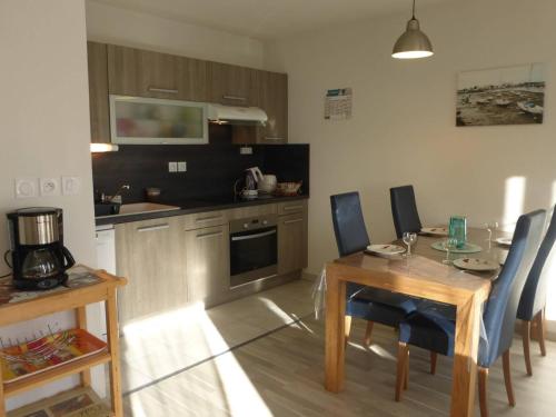 une cuisine avec une table et des chaises ainsi qu'une salle à manger dans l'établissement Agréable T2 à 1,5km du centre, proche plage, balcon, parking privé, ascenseur, 4 couchages - FR-1-224-447, à Saint-Gilles-Croix-de-Vie
