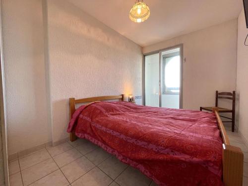 une chambre avec un lit avec une couverture rouge dans l'établissement Appartement 2 pièces 6 couchages avec balcon fermé à Saint-Gilles-Croix-de-Vie - FR-1-224-307, à Saint-Gilles-Croix-de-Vie