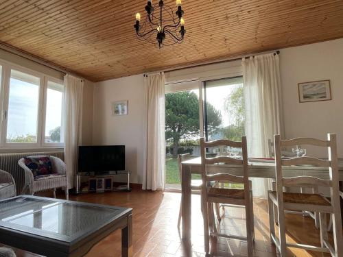 un salon avec une table, des chaises et une télévision dans l'établissement Maison avec Jardin Clos près de la Plage - 5 Couchages, 3 Étoiles, Ménage Inclus - FR-1-224B-474, à Barbâtre
