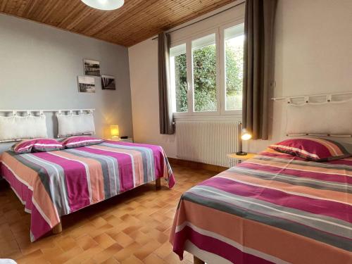 une chambre avec deux lits et une fenêtre dans l'établissement Maison avec Jardin Clos près de la Plage - 5 Couchages, 3 Étoiles, Ménage Inclus - FR-1-224B-474, à Barbâtre
