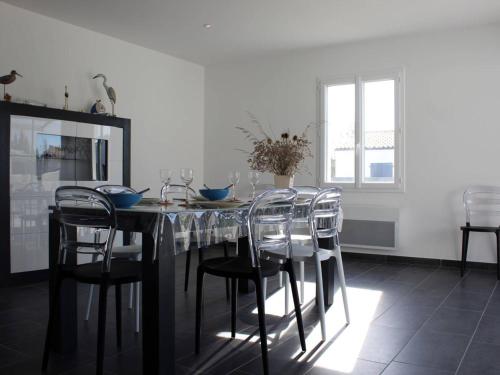 une salle à manger avec une table et des chaises dans l'établissement Maison moderne à Saint-Pierre-d'Oléron avec jardin, terrasse, 5 couchages, proche commerces - FR-1-246A-12, à Saint-Pierre-dʼOléron