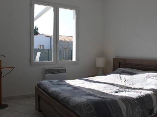 une chambre avec un lit et une fenêtre dans l'établissement Maison moderne à Saint-Pierre-d'Oléron avec jardin, terrasse, 5 couchages, proche commerces - FR-1-246A-12, à Saint-Pierre-dʼOléron