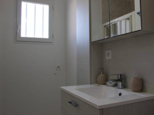 une salle de bain avec un lavabo blanc et une fenêtre dans l'établissement Maison moderne à Saint-Pierre-d'Oléron avec jardin, terrasse, 5 couchages, proche commerces - FR-1-246A-12, à Saint-Pierre-dʼOléron