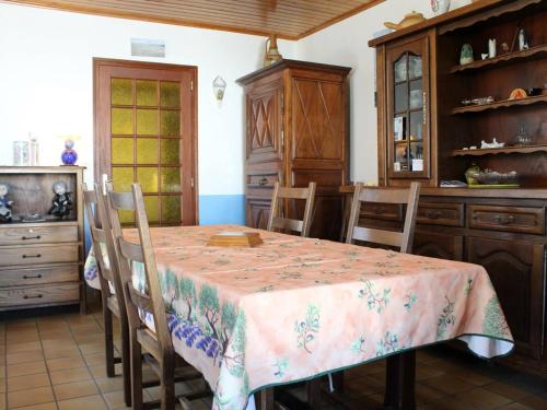 une salle à manger avec une table et des chaises et une cuisine dans l'établissement Maison calme avec jardin clos, à proximité de la plage et des pistes cyclables, 4 couchages - FR-1-246A-376, à Foulerot