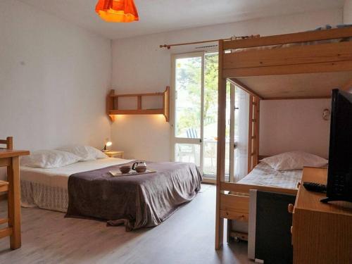 - une chambre avec 2 lits superposés et une télévision dans l'établissement Studio cosy avec jardinet à 300m de la plage - 4 couchages - FR-1-224B-689, à La Guérinière