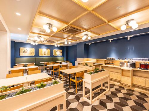 a dining room with tables and chairs in a restaurant at La'gent Hotel Kyoto Nijo in Kyoto