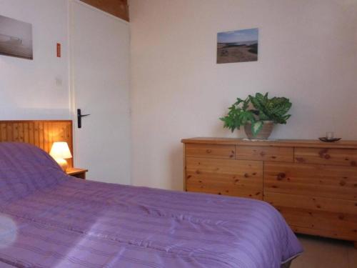 um quarto com uma cama roxa e uma cómoda em madeira em Maison Bretignolles-sur-Mer, 2 pièces, 4 personnes - FR-1-224A-586 em Bretignolles-sur-Mer