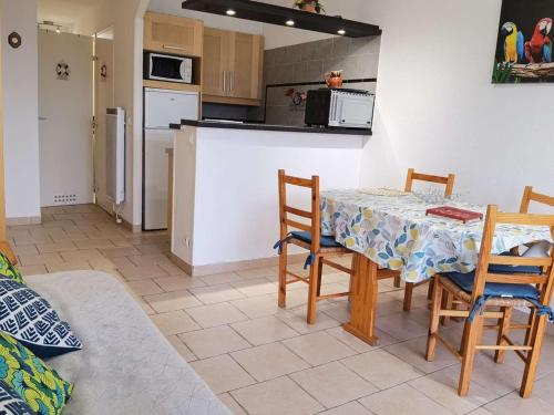 une cuisine et une salle à manger avec une table et des chaises dans l'établissement Charmant appartement T2 cabine, proche plage, commerces, parking privé, terrasse sud-est, 5 pers - FR-1-326-582, à Marseillan