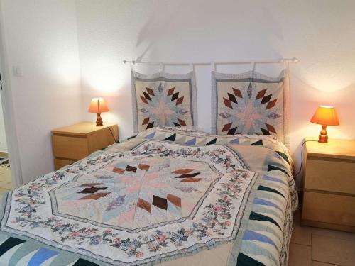 une chambre avec un lit avec une couette dessus dans l'établissement Charmant appartement T2 cabine, proche plage, commerces, parking privé, terrasse sud-est, 5 pers - FR-1-326-582, à Marseillan