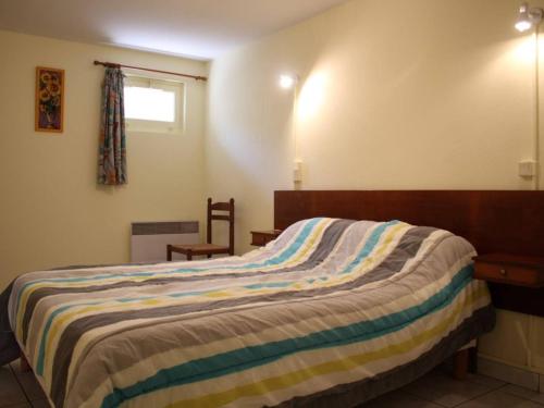 une chambre avec un lit avec une couverture rayée dans l'établissement Maison près du port de La Cotinière, 4 couchages, terrasse, véranda, parking sur propriété - FR-1-246A-31, à La Cotinière