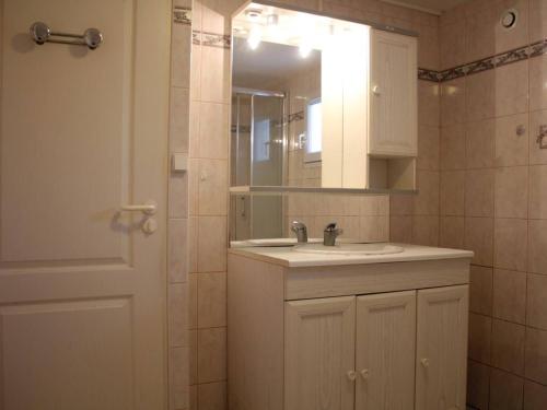 La salle de bains est pourvue d'un lavabo, d'un miroir et d'une porte. dans l'établissement Maison près du port de La Cotinière, 4 couchages, terrasse, véranda, parking sur propriété - FR-1-246A-31, à La Cotinière
