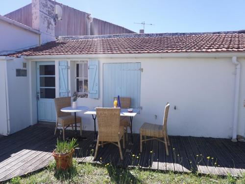 un patio avec une table et des chaises sur une terrasse dans l'établissement Maison rénovée avec jardin, proche plage, 4 couchages, Barbâtre - FR-1-224B-744, à Barbâtre