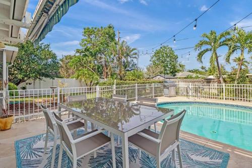 a patio with a table and chairs next to a swimming pool at House w/ heated pool in Naples 5 min to beach in Naples
