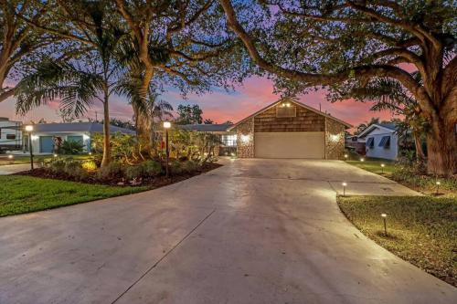 a driveway leading to a house with a garage at House w/ heated pool in Naples 5 min to beach in Naples