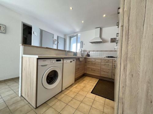 une cuisine avec une machine à laver et un évier dans l'établissement Maison agréable proche plage et bourg, 6 couchages, terrasse et équipements complets, La Guérinière - FR-1-224B-42, à La Guérinière