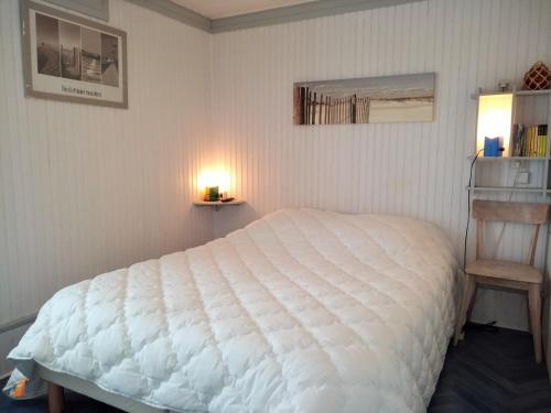 une chambre avec un grand lit blanc dans une pièce dans l'établissement Maison agréable proche plage et bourg, 6 couchages, terrasse et équipements complets, La Guérinière - FR-1-224B-42, à La Guérinière