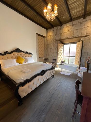 ケツァルテナンゴにあるHotel Vintage "Rialto"の大きなベッドとシャンデリアのある寝室