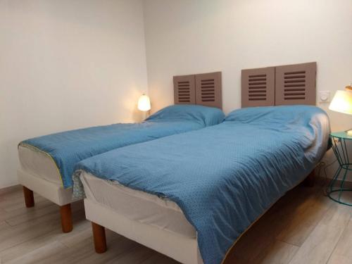 une chambre avec un grand lit avec des draps bleus dans l'établissement Maison rénovée près de la plage avec jardin clos, 300m de la mer, La Guérinière - FR-1-224B-69, à La Guérinière