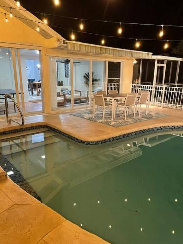 a swimming pool in a house with a table and chairs at House w/ heated pool in Naples 5 min to beach in Naples