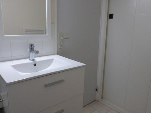 une salle de bain blanche avec un lavabo et un miroir dans l'établissement Appartement Vue Mer, Accès Direct Plage, Parking Privé, Saint-Gilles-Croix-de-Vie - FR-1-224-770, à Saint-Gilles-Croix-de-Vie