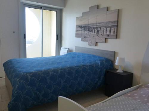 une chambre avec un lit bleu et une fenêtre dans l'établissement Appartement Vue Mer, Accès Direct Plage, Parking Privé, Saint-Gilles-Croix-de-Vie - FR-1-224-770, à Saint-Gilles-Croix-de-Vie
