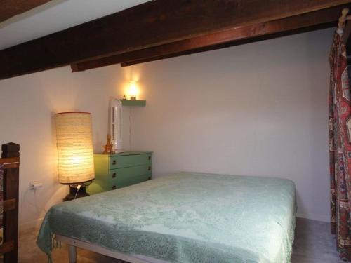 - une chambre avec un lit vert et une lampe dans l'établissement Charmant studio mezzanine pour 4 pers. à 800m de la plage avec piscine et tennis - FR-1-229D-85, à Fleury