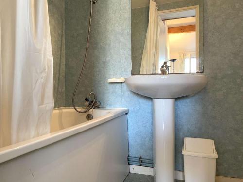 La salle de bains est pourvue d'un lavabo, d'un miroir et d'une baignoire. dans l'établissement Maison à 200m de la mer, piscine chauffée, 4 couchages, parking privé, terrasse - Bretignolles-sur-Mer - FR-1-224A-50, à Bretignolles-sur-Mer