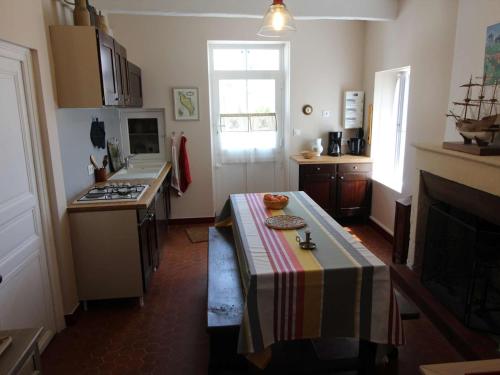 une cuisine avec une table au milieu dans l'établissement Maison rénovée 4 pièces, proche plage, 7 couchages, jardin clos, Dolus-d'Oléron - FR-1-246A-119, à Dolus-d'Oléron