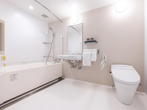 a white bathroom with a toilet and a sink at La'gent Hotel Kyoto Nijo in Kyoto