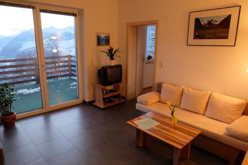 Una sala de estar con un sofá y un televisor. en Apart Panoramablick, en Kaunerberg