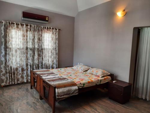 een kleine slaapkamer met een bed en een raam bij Alite Posh 4 BHK Villa in Thrissur Town in Trichūr