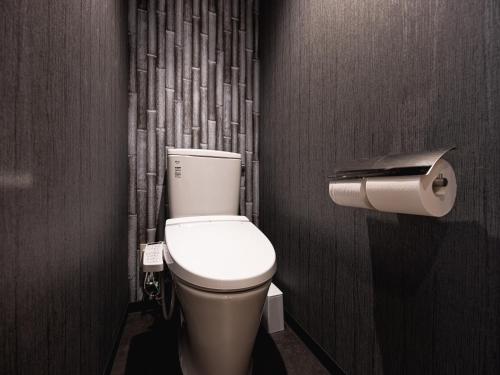 a bathroom with a toilet and a toilet paper dispenser at La'gent Hotel Kyoto Nijo in Kyoto