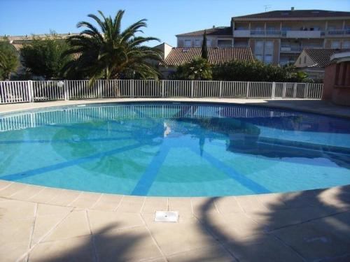 une grande piscine avec de l'eau bleue dans l'établissement Maison en Duplex au Lavandou avec Piscine, Terrasse et Parking Privé - 3 Pièces, 6 Couchages - FR-1-251-20, au Lavandou