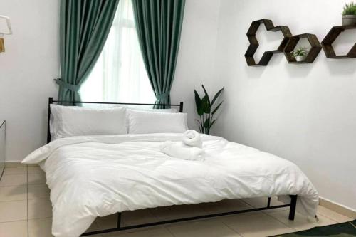 Un dormitorio con una cama blanca con una toalla. en LAMAN KASEH Homestay Bukit Katil Melaka, en Ayer Keroh