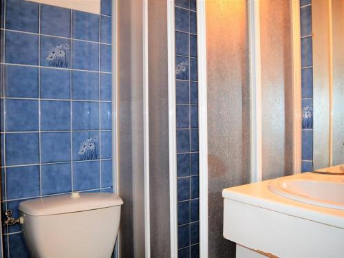 La salle de bains est pourvue de carrelage bleu, de toilettes et d'un lavabo. dans l'établissement Studio coin nuit 4 pers, parking, animaux admis, proche plage - Le Lavandou - FR-1-251-230, au Lavandou