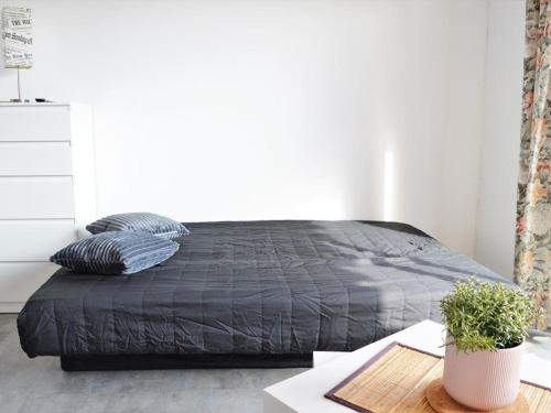 - un lit avec une couette noire dans une chambre dans l'établissement Studio 4 couchages avec terrasse, parking et proche plage au Lavandou - FR-1-251-240, au Lavandou