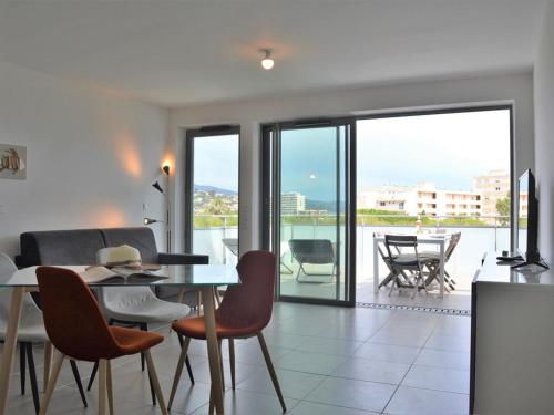 une salle à manger avec une table et des chaises et une vue sur un balcon dans l'établissement Appartement moderne avec terrasse, parking et proche plage au Lavandou - 2 étoiles - FR-1-251-331, au Lavandou